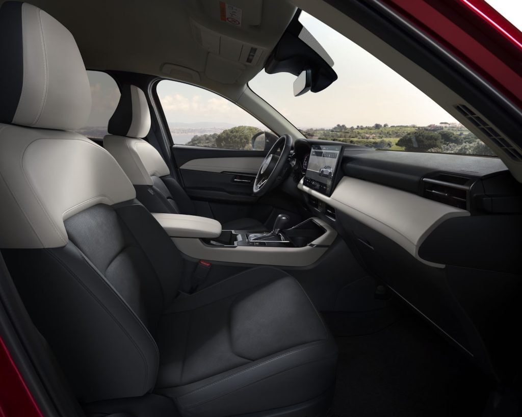 Interior view of the 2026 Mazda CX-5 showcasing comfortable seating and a modern dashboard with a scenic background.