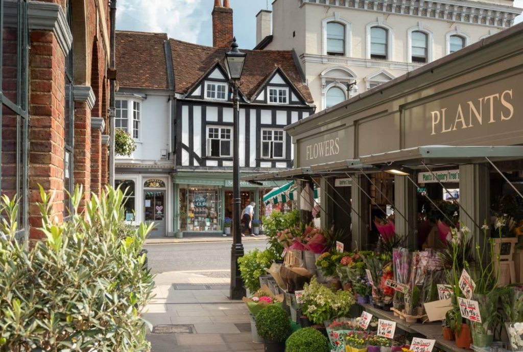 Charming street scene in Farnham featuring a flower shop and historic buildings, highlighting the town's blend of tradition and modernity.