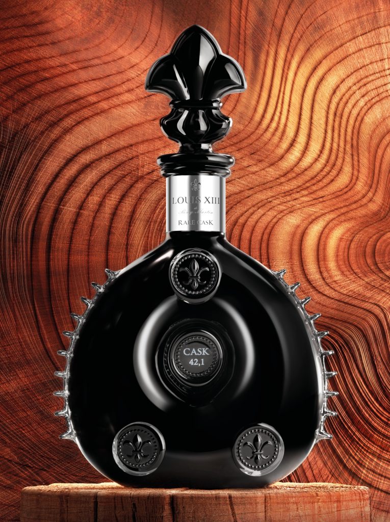 Black crystal decanter of LOUIS XIII Rare Cask 42.1 against a wooden background, featuring intricate detailing and a distinctive shape.