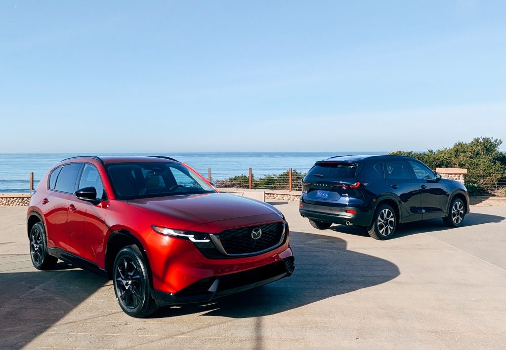 Two Mazda CX-5 SUVs parked outdoors with an ocean view in La Jolla, showcasing the 2026 model's design.
